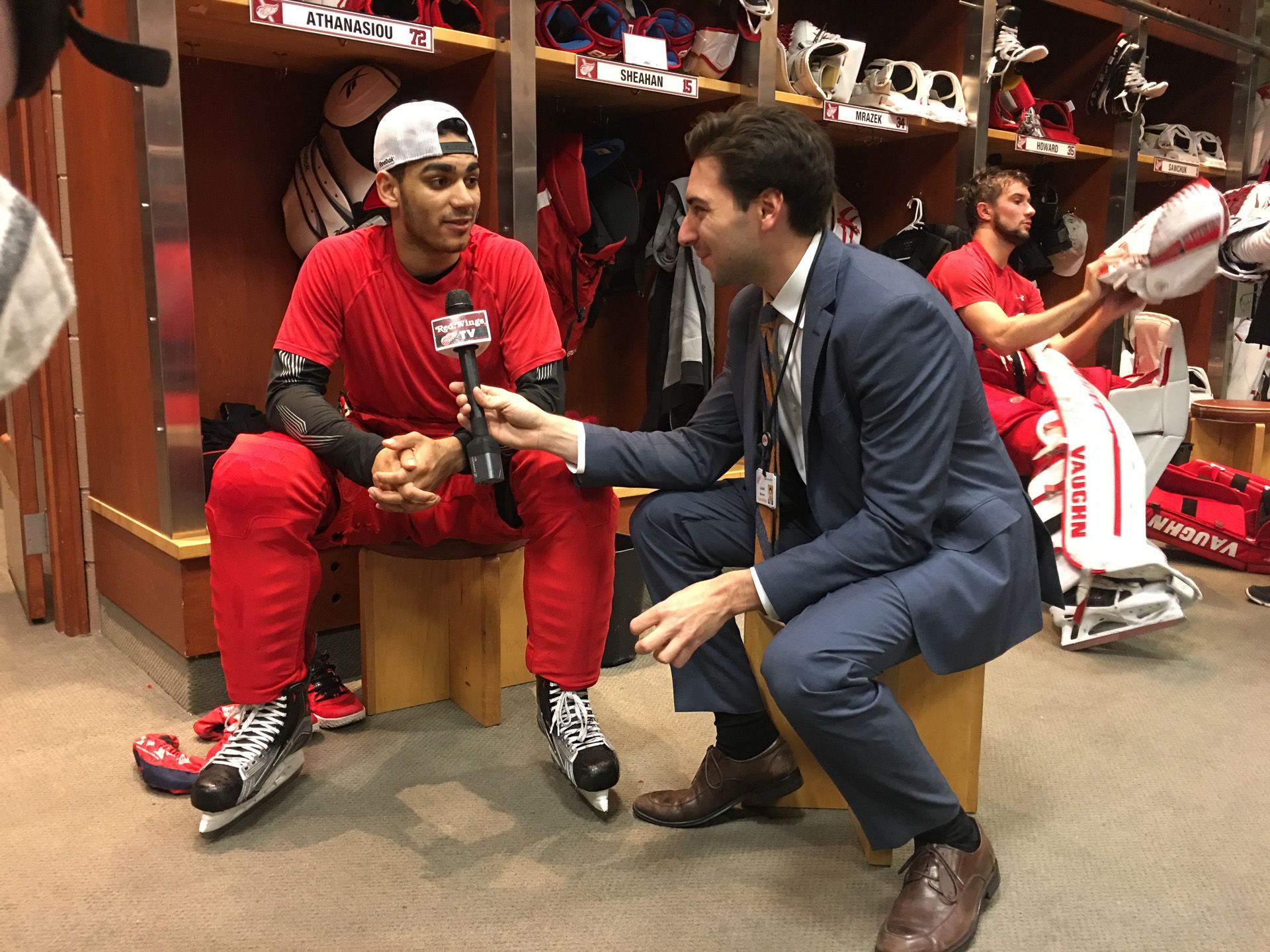 Dan interviewing a seated Red Wings player in the locker room