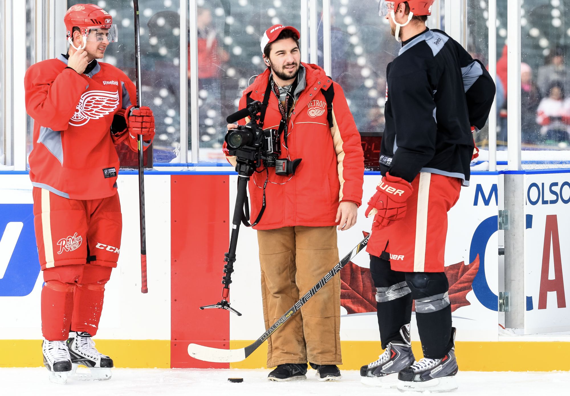 Dan on an outdoor rink between two Red Wings players